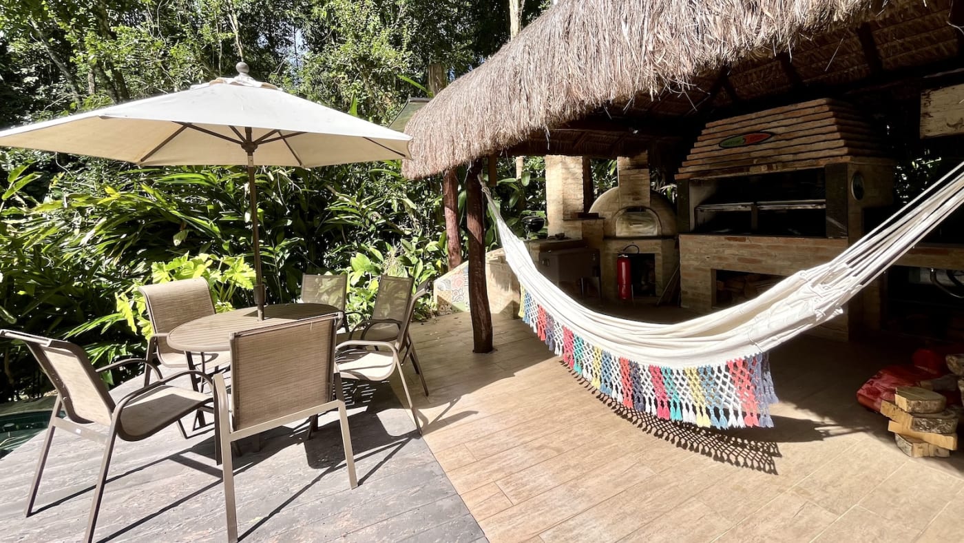 Espaço gourmet com cobertura em sapê e rede