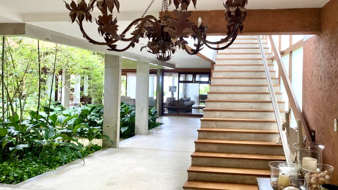 Hall integrado com jardim interno e escada em madeira