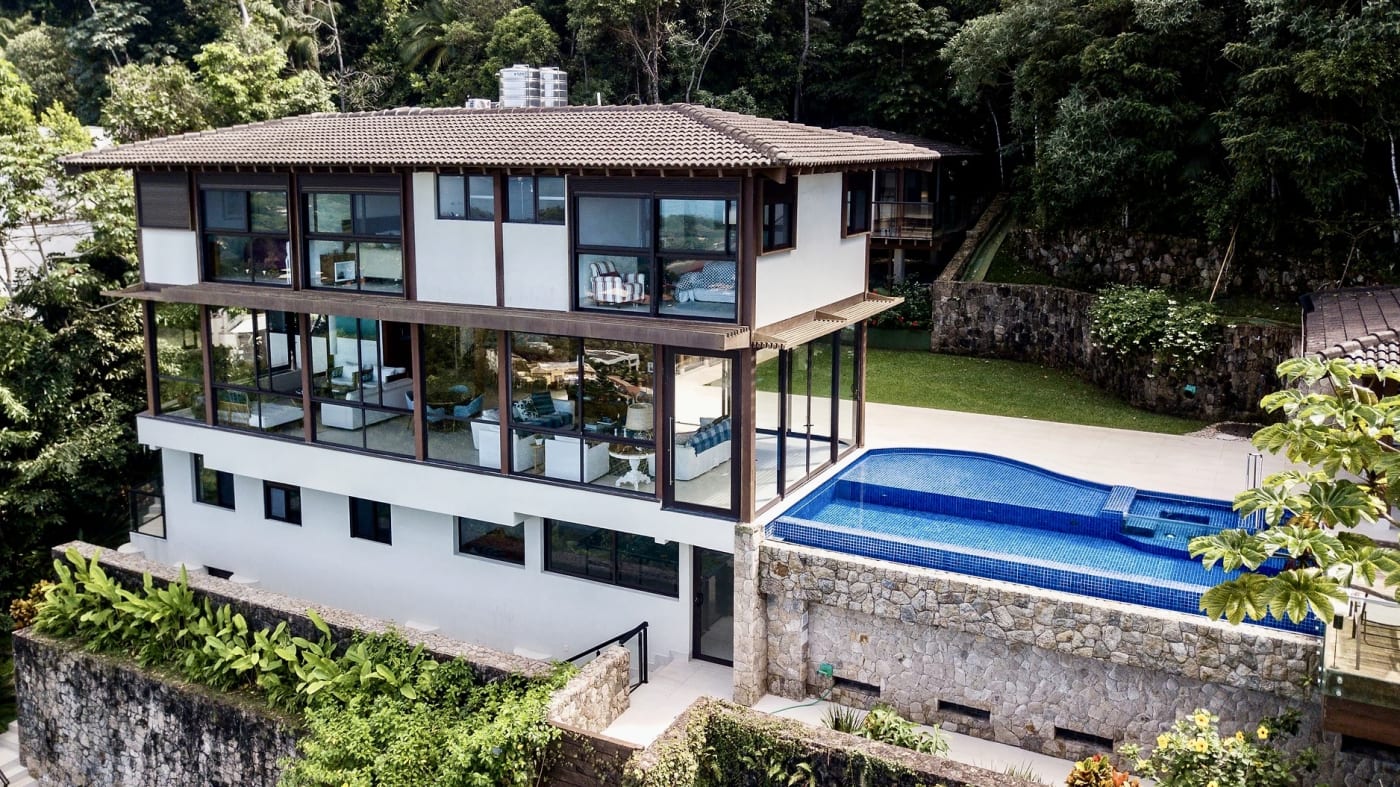 Fachada posterior com piscina integrada ao jardim