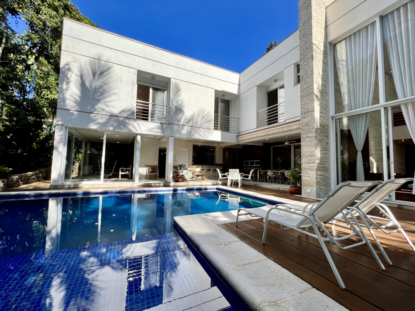 Conjunto arquitetônico com piscina e deck em madeira