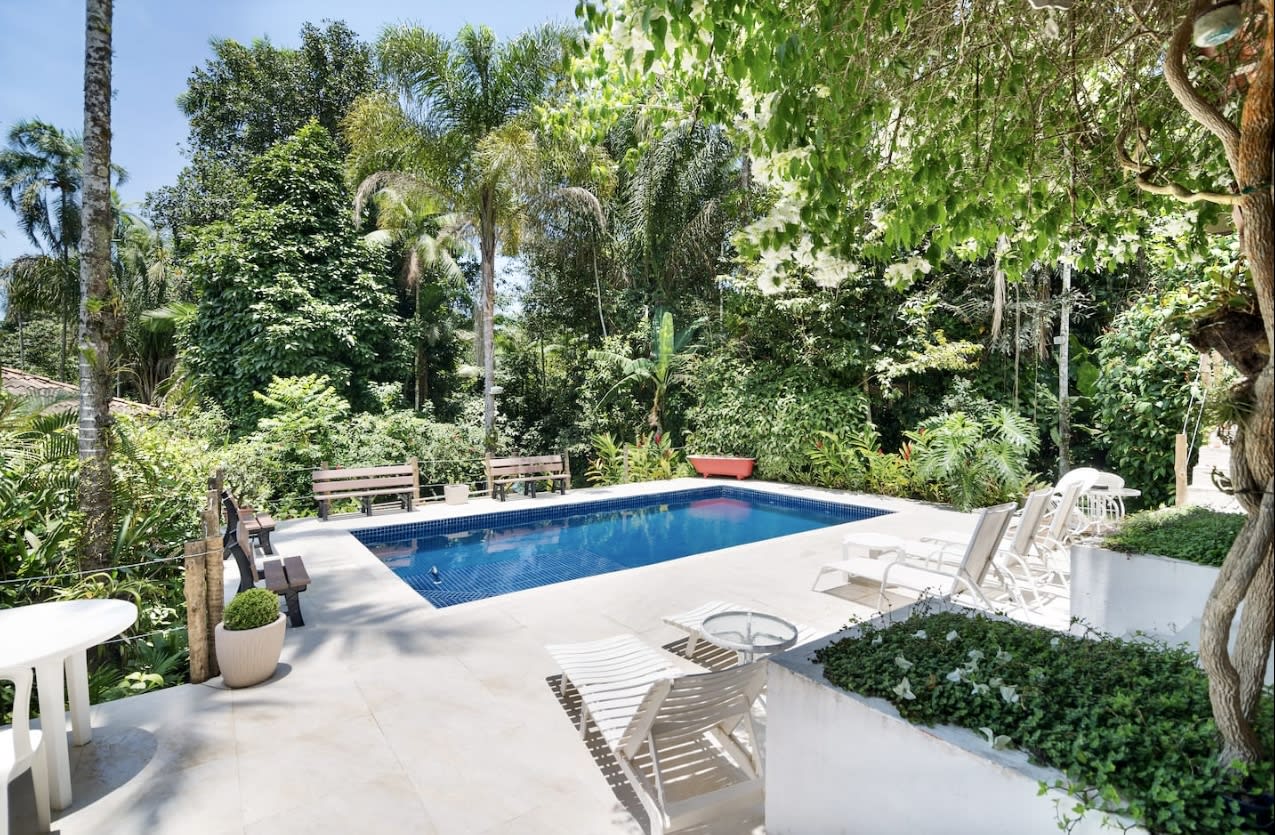 Piscina cercada por vegetação tropical exuberante