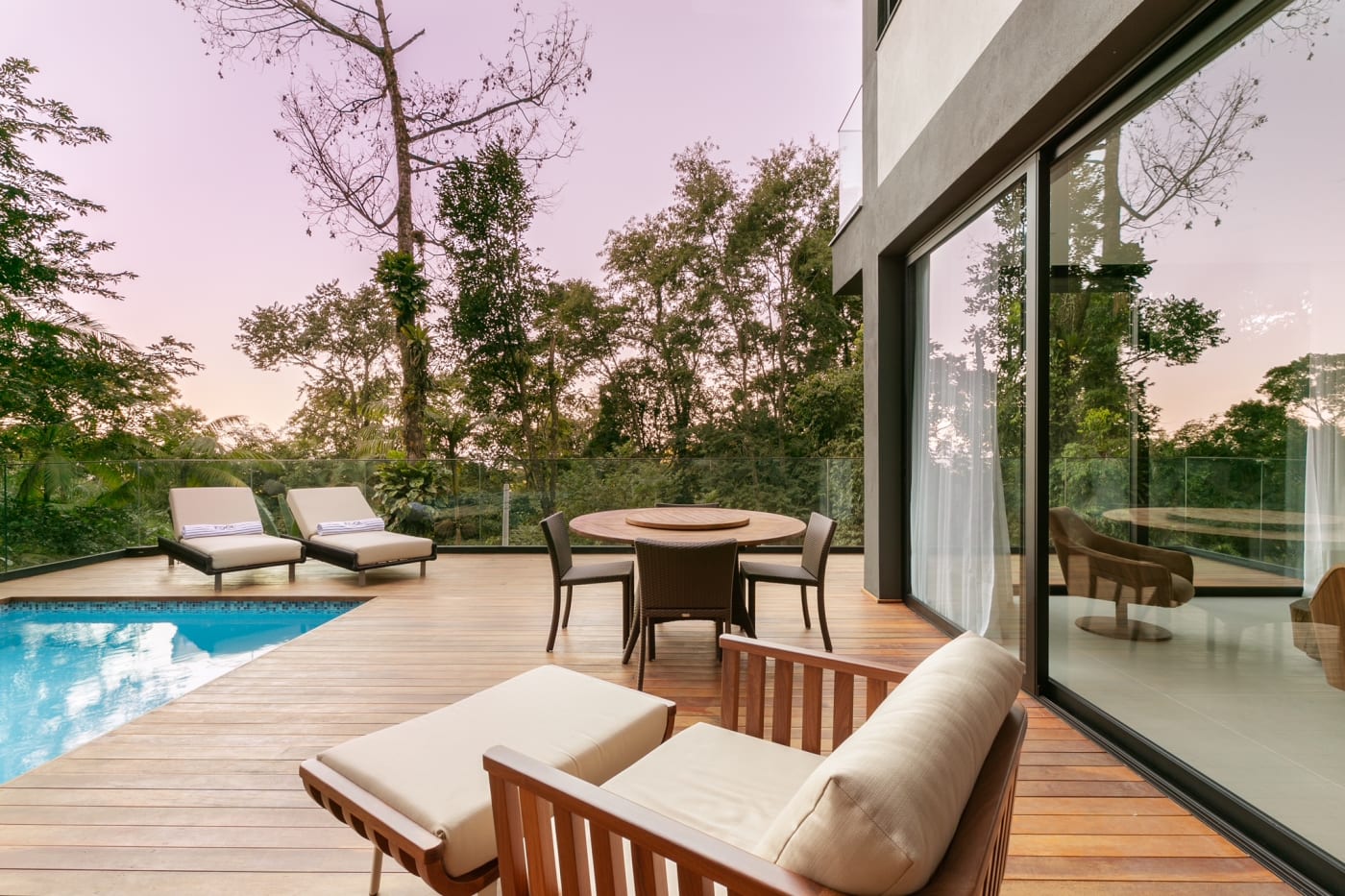 Deck integrado com piscina e mobiliário ao entardecer