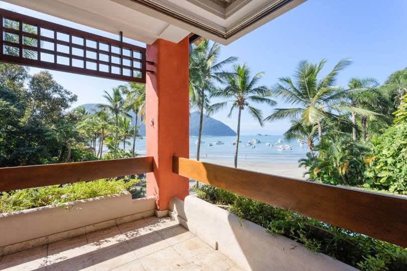 Varanda com vista para o mar e vegetação tropical