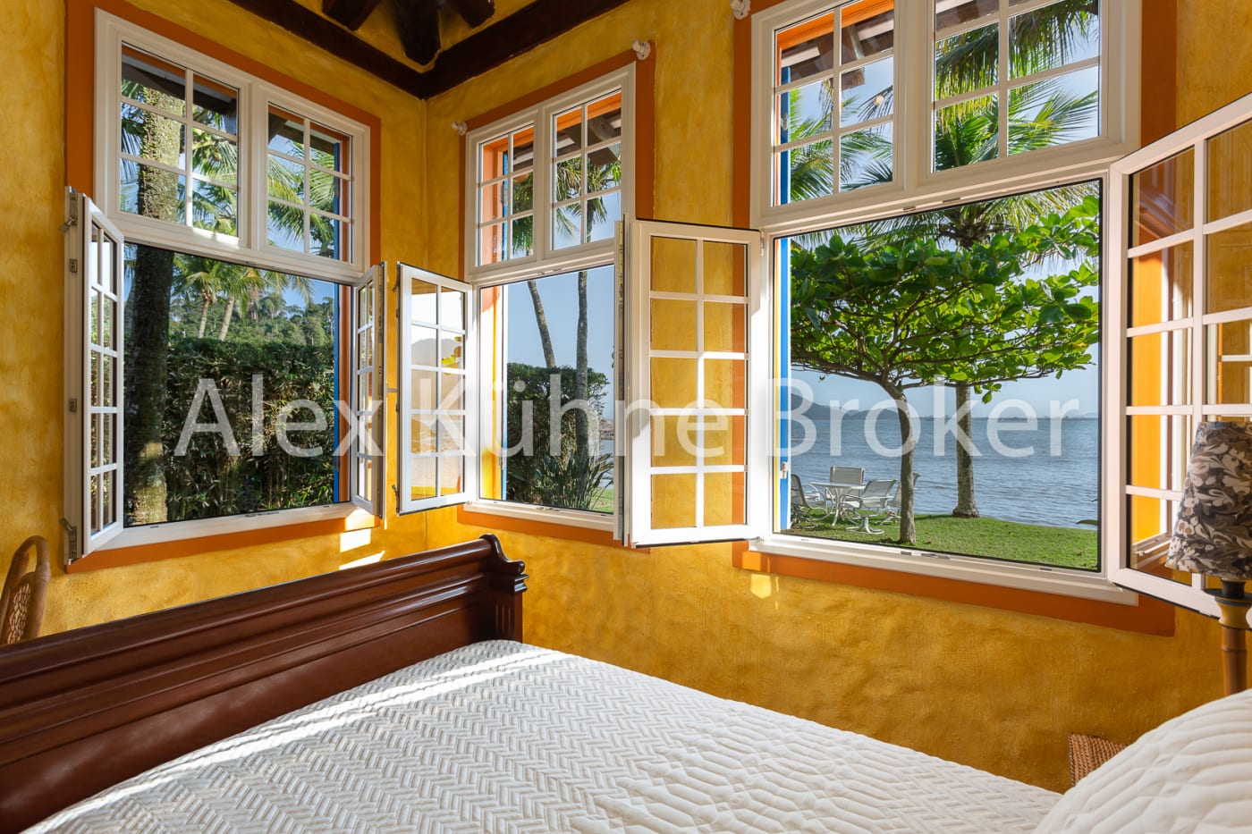 Quarto com janelas amplas abertas para paisagem