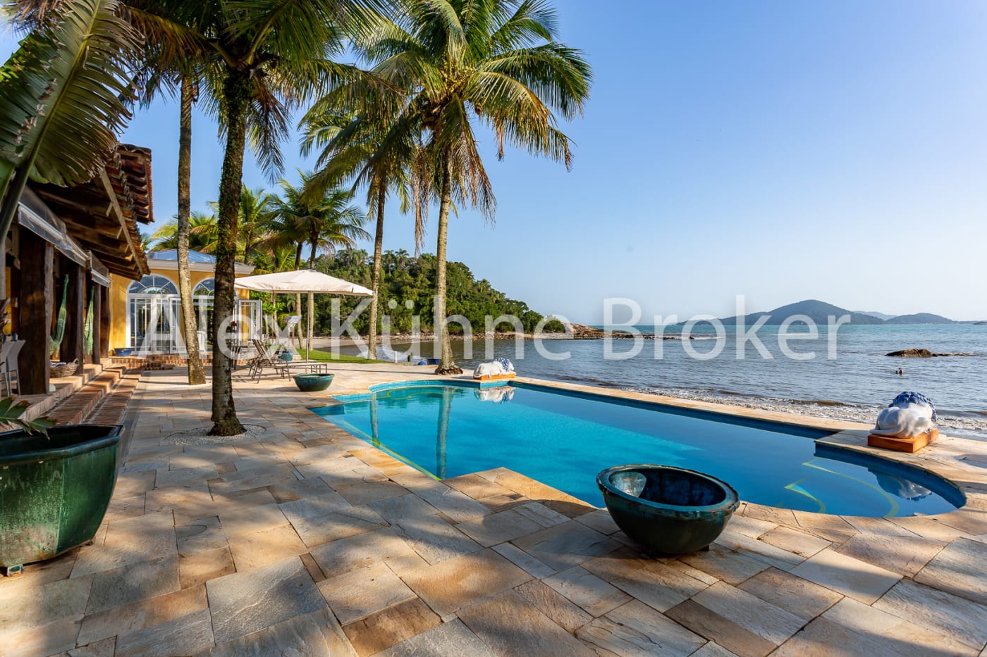 Piscina à beira-mar com coqueiros e vista privilegiada