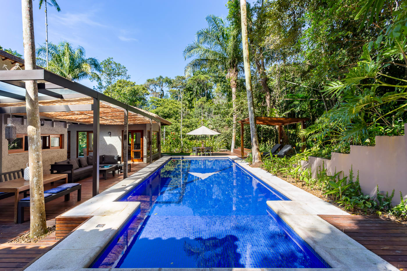 Vista longitudinal da piscina cercada por natureza