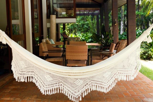 Varanda integrada ao jardim com rede decorativa