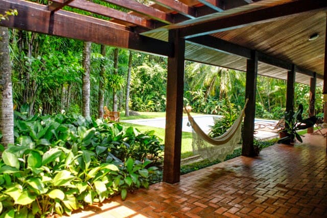 Varanda coberta com jardim tropical integrado
