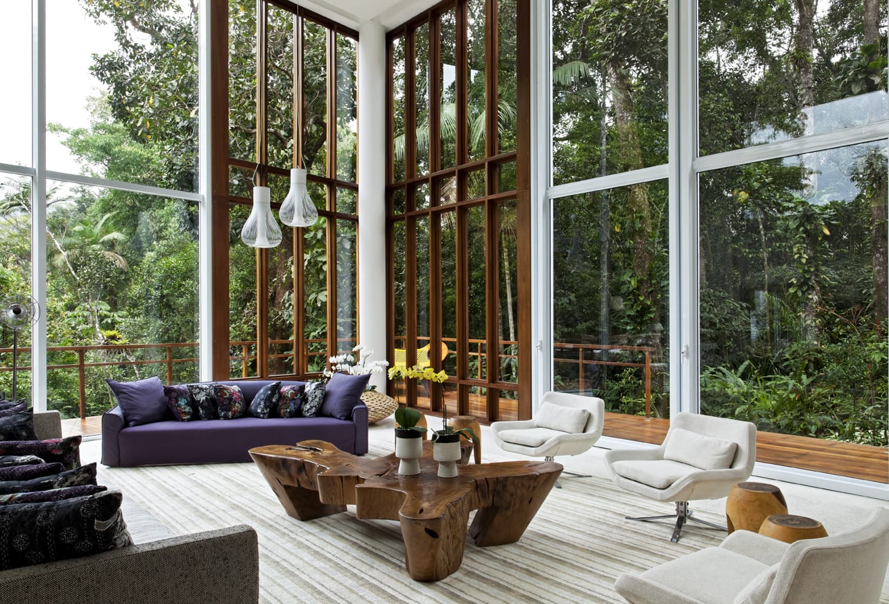 Sala de pé-direito duplo integrada ao jardim