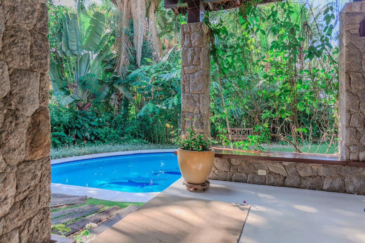 Piscina integrada ao jardim tropical exuberante