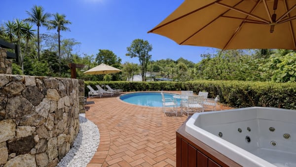 Piscina com deck em tijolinho e hidromassagem
