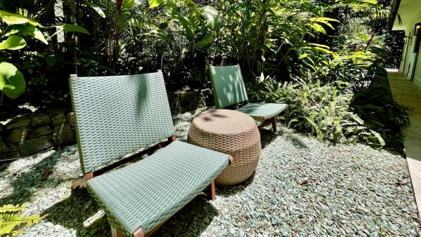 Jardim tropical com espreguiçadeiras e paisagismo exuberante