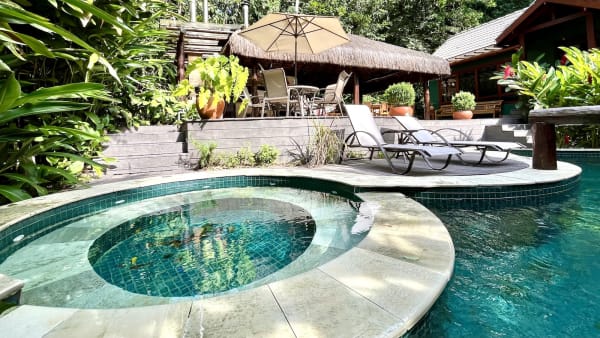 Área de lazer com piscina e guarda-sol