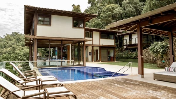 Piscina com deck em madeira e jardim