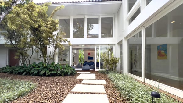 Fachada interna com jardim paisagístico e caminho de pedras