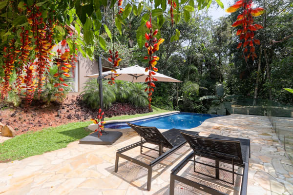 Área de lazer com piscina e jardim tropical
