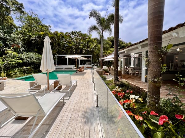 Deck de madeira com espreguiçadeiras e jardim florido