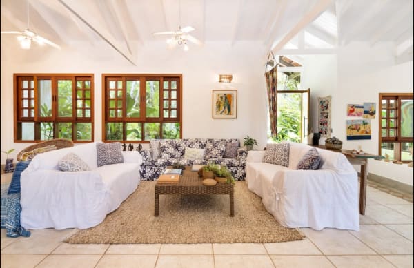 Sala de estar com pé-direito alto e esquadrias em madeira