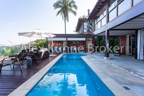 Piscina de borda infinita com deck e paisagismo