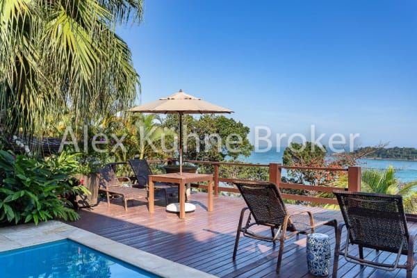 Deck em madeira com piscina e vista para o mar