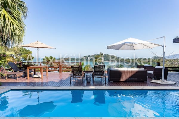 Piscina com deck em madeira e vista para o mar