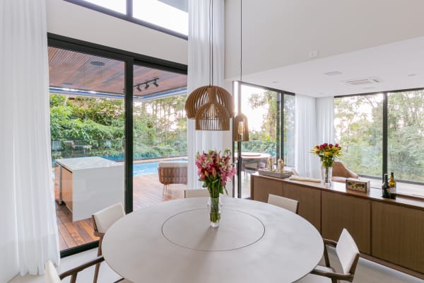 Sala de jantar integrada com luminárias e abertura total
