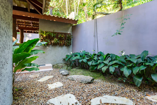 Jardim interno com pisantes e vegetação tropical