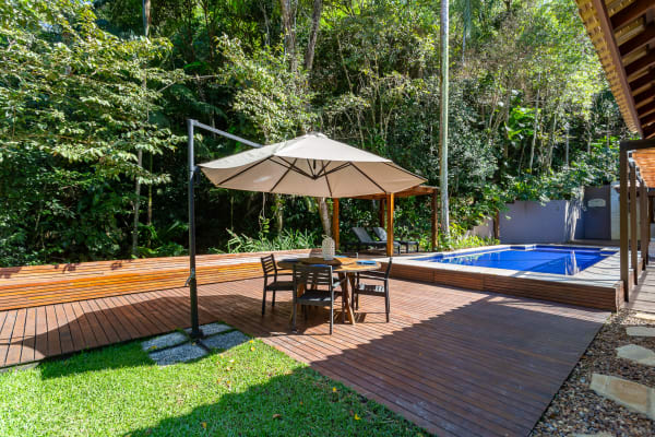 Deck em madeira com espaço gourmet e jardim