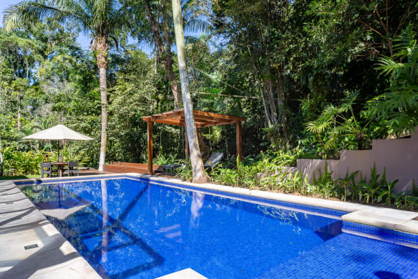 Piscina integrada ao jardim tropical exuberante
