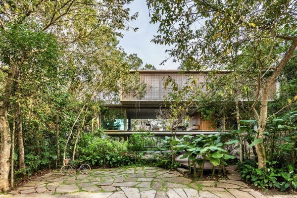 Fachada suspensa integrada ao jardim tropical