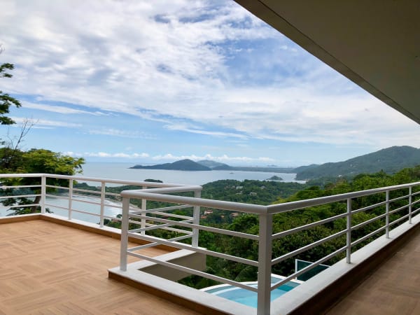 Varanda ampla com guarda-corpo branco e paisagem