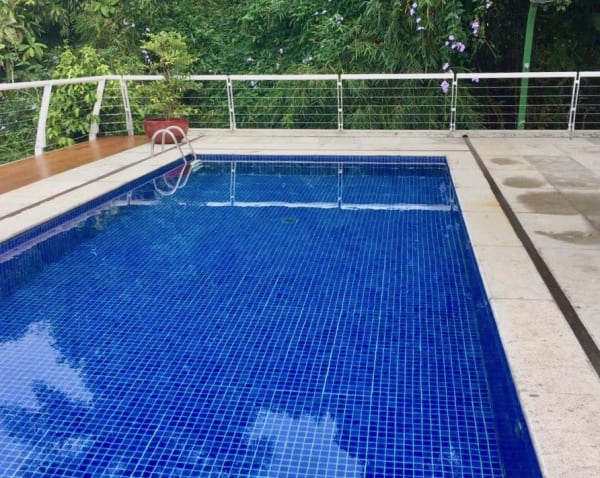 Piscina em pastilha azul com área de lazer