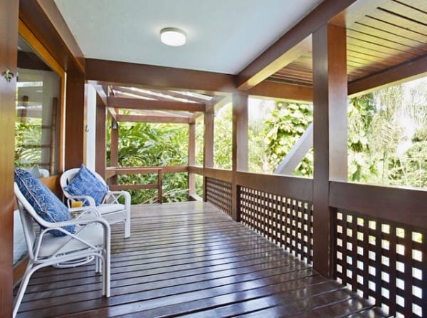 Varanda com deck em madeira e guarda-corpo treliçado
