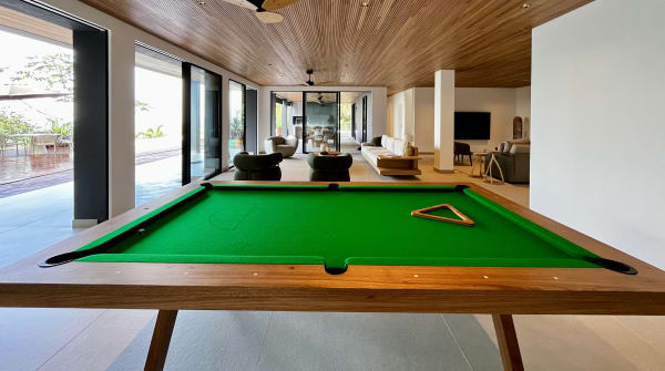 Sala integrada com mesa de sinuca e forro em madeira