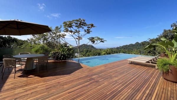 Piscina de borda infinita em deck de madeira