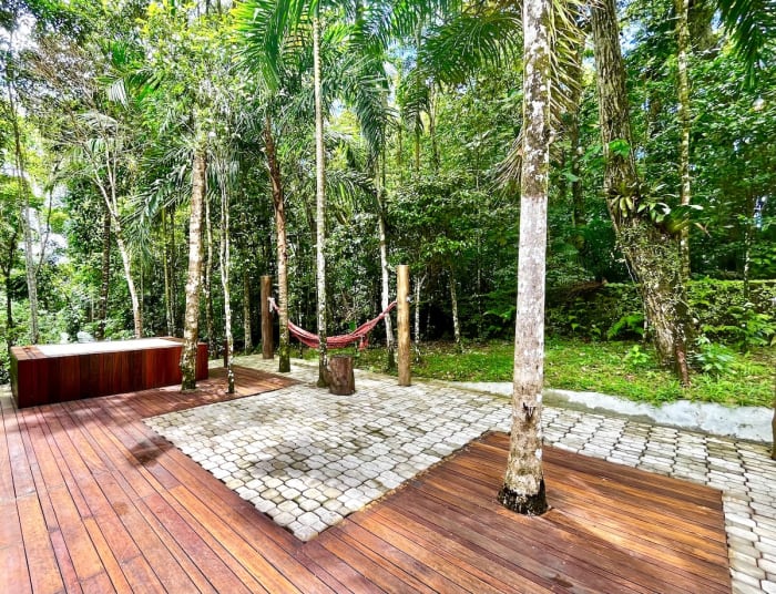 Deck em madeira com spa integrado à mata