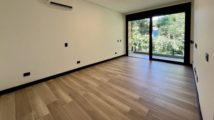 Ambiente amplo com piso de madeira e abertura total