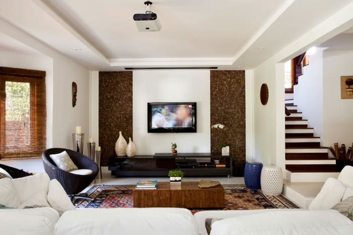 Living amplo com painel decorativo e escada interna