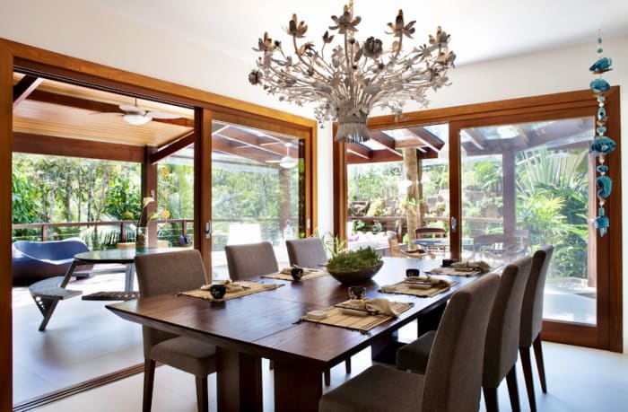 Sala de jantar integrada com amplas janelas e jardim