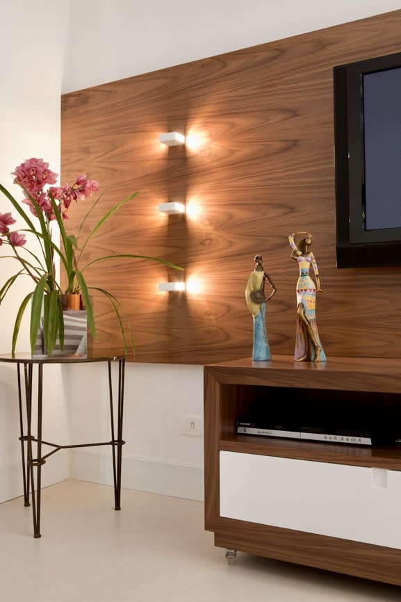 Sala com painel em madeira e iluminação indireta