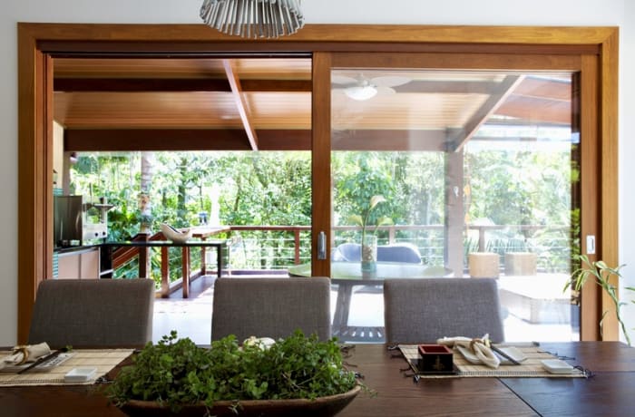 Ambiente integrado com esquadrias de madeira e vegetação