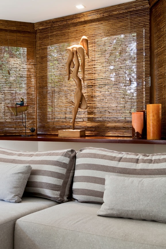 Estar com persiana de madeira e escultura decorativa