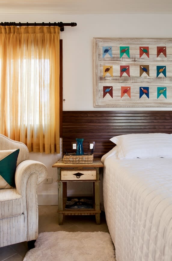 Quarto aconchegante com cabeceira de madeira e decoração colorida