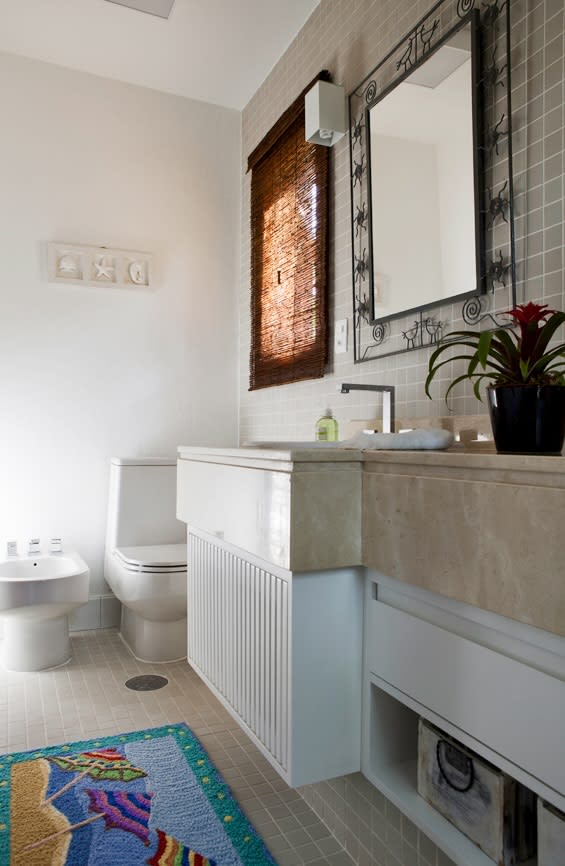 Lavabo com acabamento em pedra e espelho com moldura