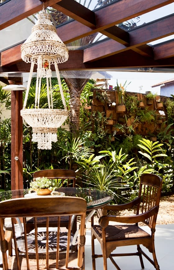 Varanda coberta com jardim vertical e lustre
