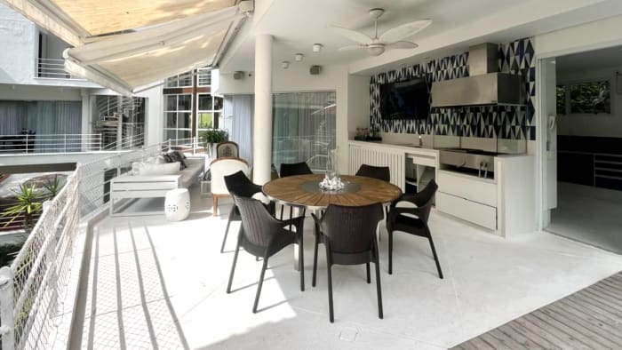 Espaço gourmet com churrasqueira e mesa integrada