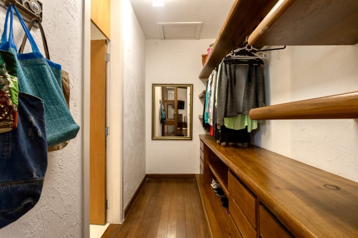 Closet com armários de madeira e iluminação embutida