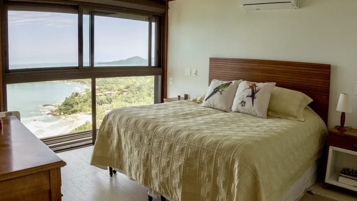 Quarto amplo com janelas voltadas para a natureza
