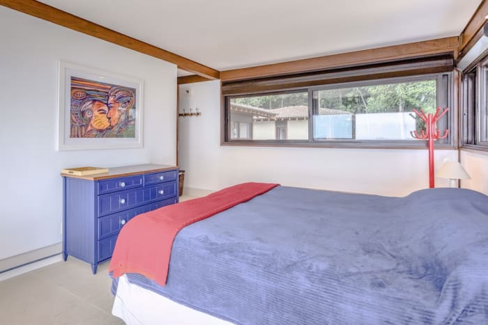 Quarto com vigas de madeira e luz natural