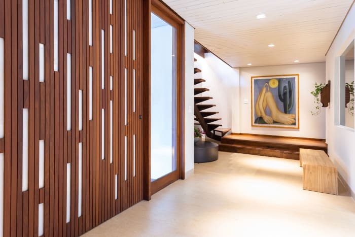 Hall com painel vazado em madeira e escultura
